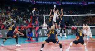 Latvian volleyball player spikes the ball during a match against Romania