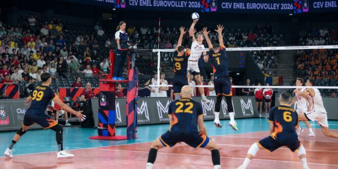 Latvian volleyball player spikes the ball during a match against Romania