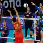 A Romanian volleyball player spikes the ball during a match.