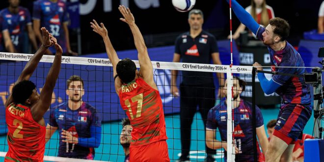 A Romanian volleyball player spikes the ball during a match.