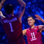 Men's volleyball players celebrating on the court