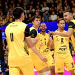 Volleyball players from Skra Bełchatów celebrating a point during a match.