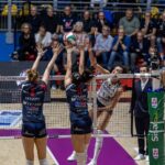 A volleyball player spikes the ball during a match.