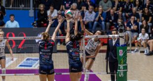 A volleyball player spikes the ball during a match.